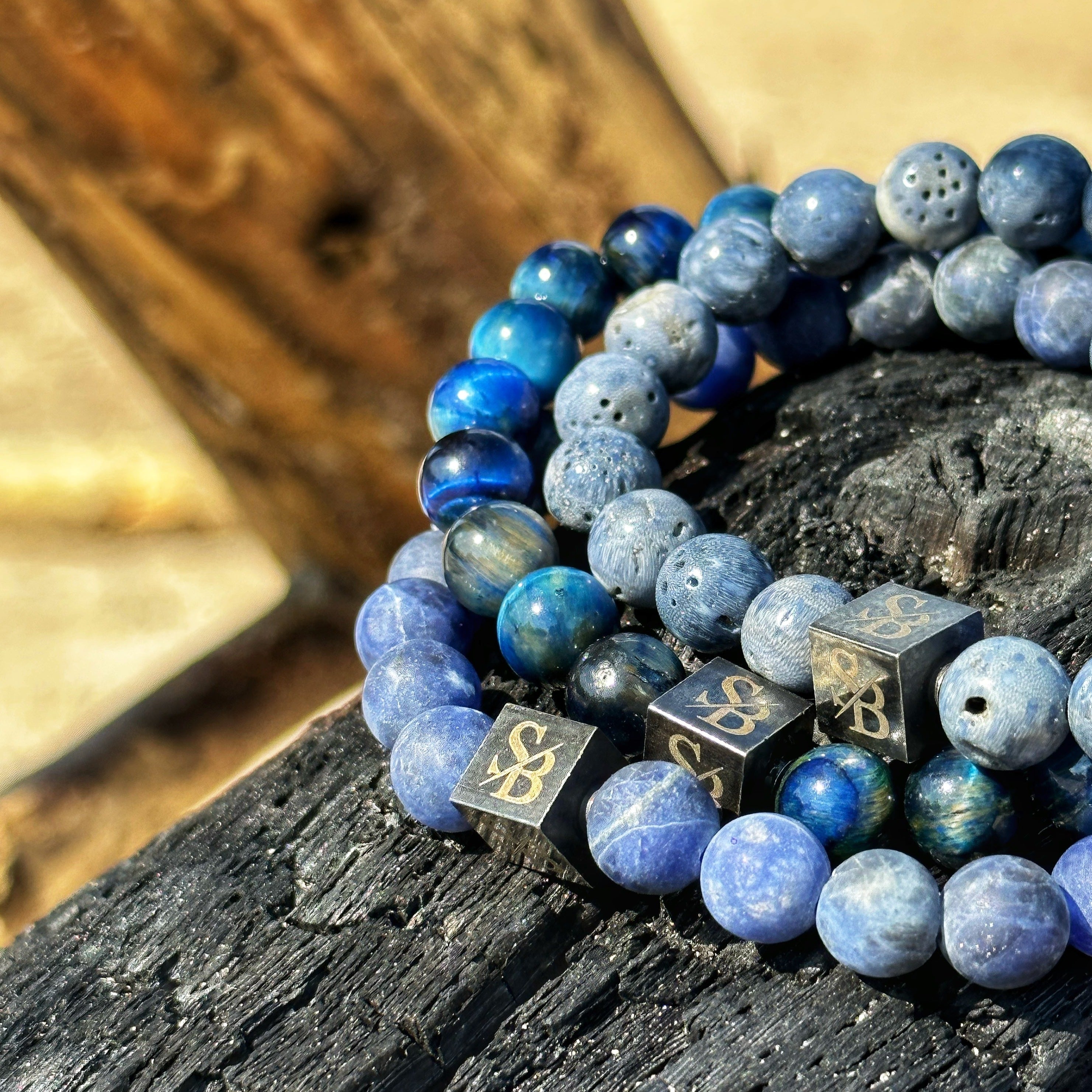 Twee Stoney Armbanden met blauwe stenen bovenop een houten tafel.