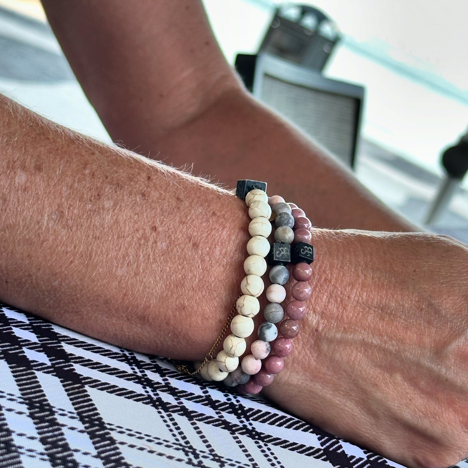 Maansteen en roze rhodoniet armbanden samen gedragen aan de pols
