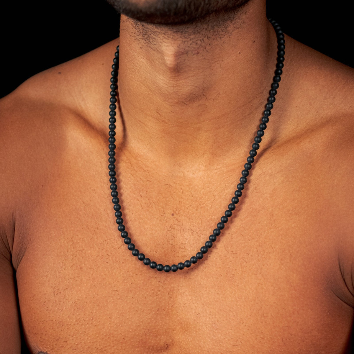Matte Obsidian Necklace (6mm) gedragen op de huid, close-up van de matte zwarte kralen | Stoney Bracelets