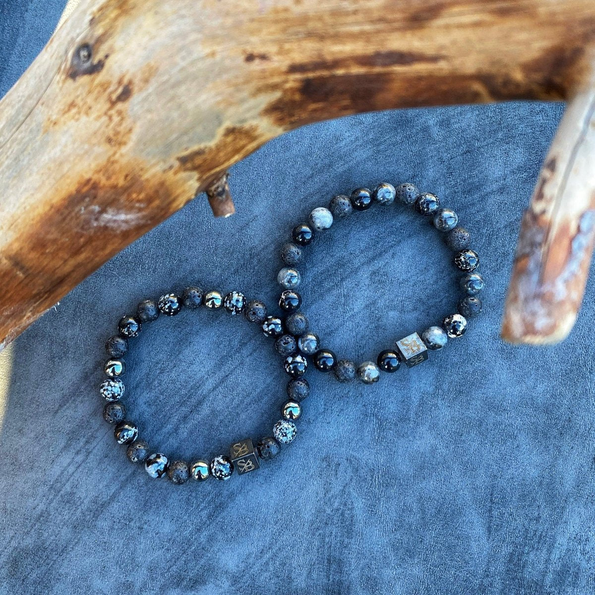 Twee vulkanische | Mixed Stones (8mm) armbanden met zwarte en blauwe kralen bovenop een hertenschedel van Stoney Bracelets.
